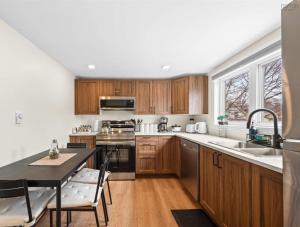 una cocina con armarios de madera y electrodomésticos de acero inoxidable en Serenity Getaway, en Halifax