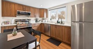 eine Küche mit Holzschränken und einem Kühlschrank aus Edelstahl in der Unterkunft Serenity Getaway in Halifax