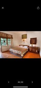 a large bedroom with a bed and a window at Puri Bebengan Bungalows in Ubud