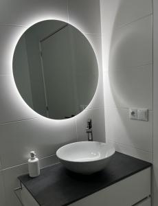 ein Badezimmer mit einem weißen Waschbecken und einem Spiegel in der Unterkunft Apartamento A Cachola in Cangas