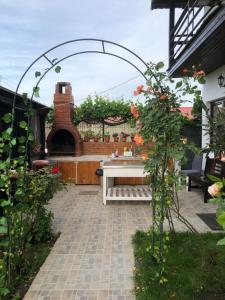 a patio with a table and a brick fireplace at Vila Rianna in Dunavăţu de Jos