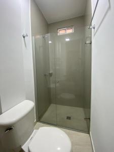 e bagno con servizi igienici e doccia in vetro. di HOTEL NES a Maicao