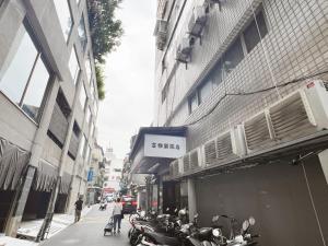 台北的住宿－富雅樂旅店，停在建筑物旁边的街道上的一群摩托车