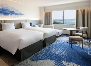 ein Hotelzimmer mit einem großen Bett und einem Tisch in der Unterkunft Grand Mercure Lake Hamana Resort & Spa in Hamamatsu