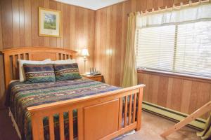 a bedroom with a wooden bed and a window at Bear Bait Cabin In Upper Valley With High Speed Wifi in Red River