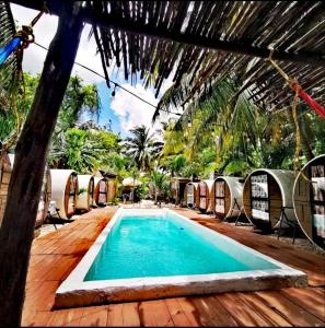 a swimming pool on a wooden deck next to a resort at Kulu Tubohostel Bacalar in Bacalar