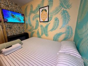 - une chambre avec un lit et une télévision murale dans l'établissement Lemon private room with shared bathroom, à New York