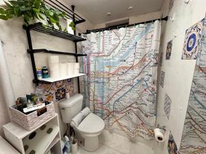 a bathroom with a map shower curtain with a toilet at King size room with shared bathroom in New York