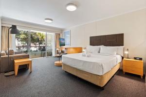 ein Schlafzimmer mit einem großen Bett und ein Wohnzimmer in der Unterkunft Manly Seabreeze in Sydney + 10 Fotos