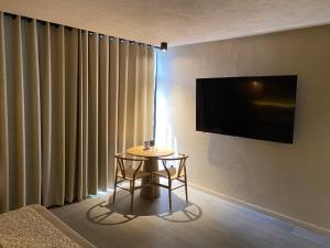 a small table in a room with a television on a wall at Motel London in Guadalajara