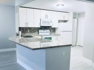 a kitchen with white cabinets and a counter top at MODERN 2BR 2BA CONDO near AVENTURA! Wi-Fi! Parking in North Miami Beach +11 photos