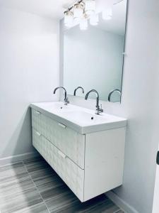 a white bathroom with a sink and a mirror at MODERN 2BR 2BA CONDO near AVENTURA! Wi-Fi! Parking in North Miami Beach