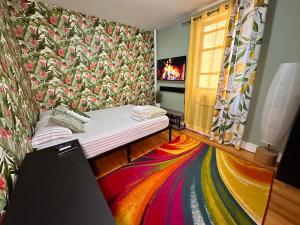 a room with a bed and a colorful carpet at queen size room with shared bathroom in New York