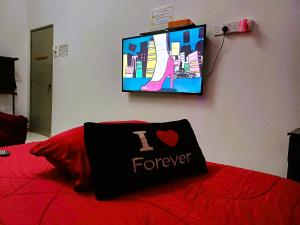 a bed with a i heart forever pillow on it at Kuantan Homestay Best Facility Wifi BBQ Viu in Kuantan