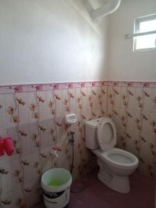 a bathroom with a toilet and a trash can at Kelsey's Homestay in Burgos