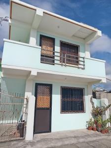 a white house with a black door and balcony at Kelsey's Homestay in Burgos