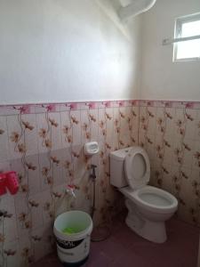 a bathroom with a toilet and a trash can at Kelsey's Homestay in Burgos