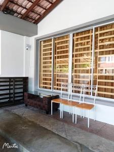 two chairs and a table in front of a window at 13Pax -2 Storey Bayu Mutiara Bukit Mertajam Penang in Bukit Mertajam