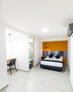 - une chambre avec un lit, un bureau et une chaise dans l'établissement HOTEL ESTADIO DORADO, à Medellín