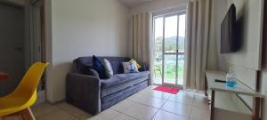 a living room with a couch and a window at Apartamento próximo praia in Florianópolis