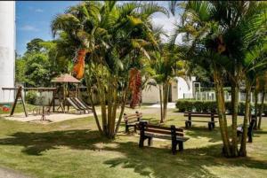 a park with benches and a playground with palm trees at Apartamento próximo praia in Florianópolis
