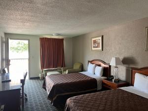 Habitación de hotel con 2 camas y ventana en American Inn Columbia en Columbia
