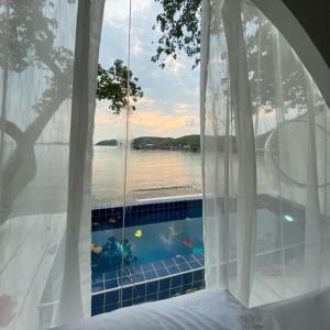 1 dormitorio con ventana y vistas al agua en Cordelia Villa Koh Larn en Ko Larn