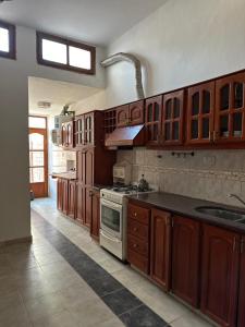 a kitchen with wooden cabinets and a stove top oven at Casa Vitta in Deán Funes