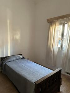 a bed in a bedroom with a window at Casa Vitta in Deán Funes
