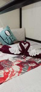 Una cama con una manta cardiaca y una almohada. en Homey Inn-Olango Island Staycation ,block 1 lot 15, en Lapu Lapu City
