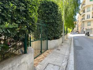 una puerta verde en una acera junto a una calle en Les clémentines, en Niza