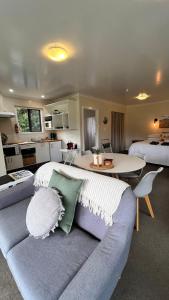 uma sala de estar com um sofá e uma mesa num quarto em Mohua Park - Catlins Eco Accommodation em Owaka