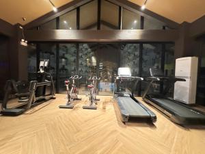 a gym with several treadmills and elliptical machines at Ania Summer Rooms in Mactan