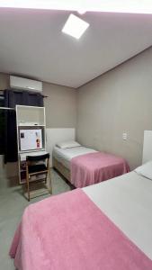 パルマスにあるMorada do Lagoのベッド2台、デスク、テレビが備わる客室です。