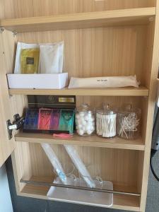 une étagère en bois avec des produits alimentaires dans une armoire dans l'établissement Hotel SERA LUNA -ホテル セラルナ-, à Naha