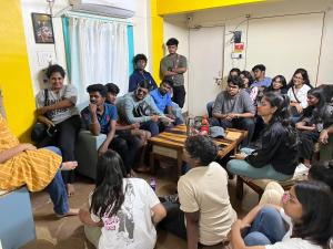 un grupo de personas sentadas en una habitación en HOSHTEL99 - Stay, Cowork and Cafe - A Backpackers Hostel, en Pune