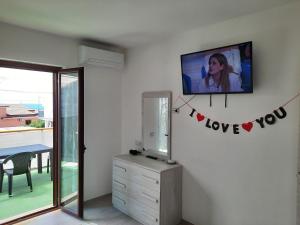 a room with a tv on a wall with hearts on it at Appartamenti Miramare in Marina di Camerota