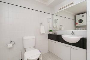 a white bathroom with a sink and a toilet at 2X1 Comfy Apartment in Perth CBD in Perth +11 photos