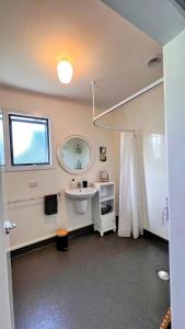 Mohua Park - Catlins Eco Accommodation في Owaka: حمام مع حوض ومرآة