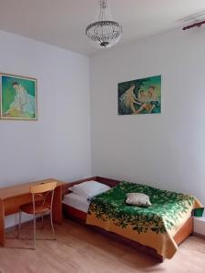 a bedroom with a bed and a chair and a chandelier at Veteranu 5 Visaginas in Visaginas
