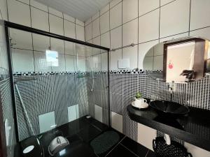 y baño con ducha acristalada y lavamanos. en Apartamento INTEIRO próximo ao Aeroporto, en Marabá