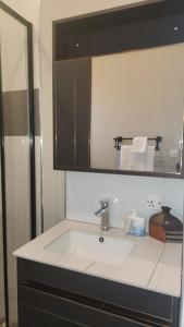 uma cozinha com um lavatório e um espelho em Villa Serene Lusaka em Lusaka