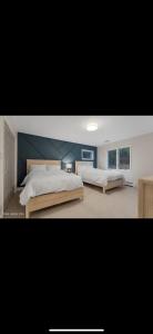 ein Schlafzimmer mit 2 Betten und einer blauen Wand in der Unterkunft Lake George Serene Retreat in Diamond Point