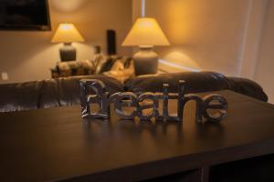 a wooden table with the word racism in front of a couch at By the Sea in Campbell River