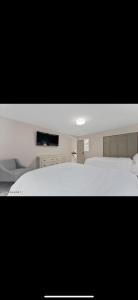 a bedroom with a large white bed and a black background at Lake George Serene Retreat in Diamond Point