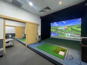 um quarto com um ecrã grande e um jogo de vídeo em KOVIE HOTEL em Ðoan Xá