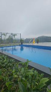 a large blue swimming pool with a playground at Golden Meadows Resort By Dwellsmith Virtue in Vagamon