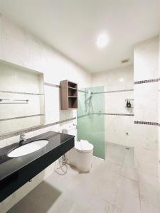 a bathroom with a toilet and a sink and a shower at The Wellbeing House in Hat Yai