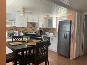 弗利蓋特灣的住宿－希羅夫茨海灘上酒店，厨房配有桌椅和冰箱。