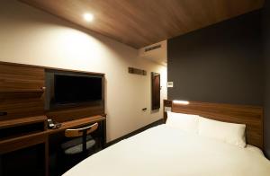 a hotel room with a bed and a television at Sotetsu Fresa Inn Nihombashi Kayabacho in Tokyo